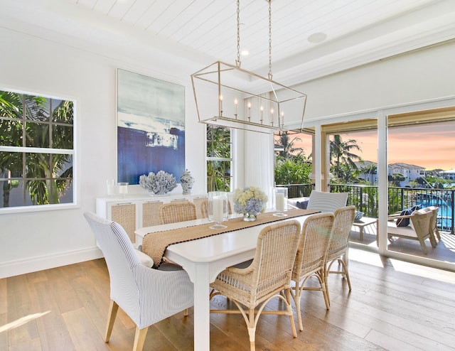 dining area featuring light hardwood / wood-style flooring, wood ceiling, and an inviting chandelier