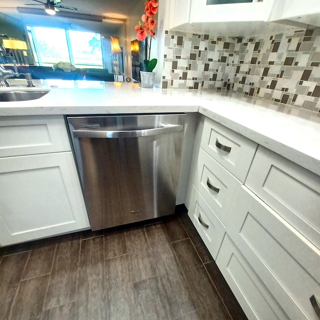 kitchen with stainless steel dishwasher, dark wood-type flooring, and white cabinets