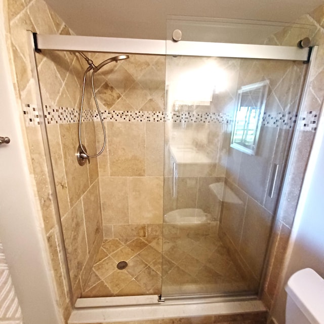 full bathroom with a stall shower and toilet