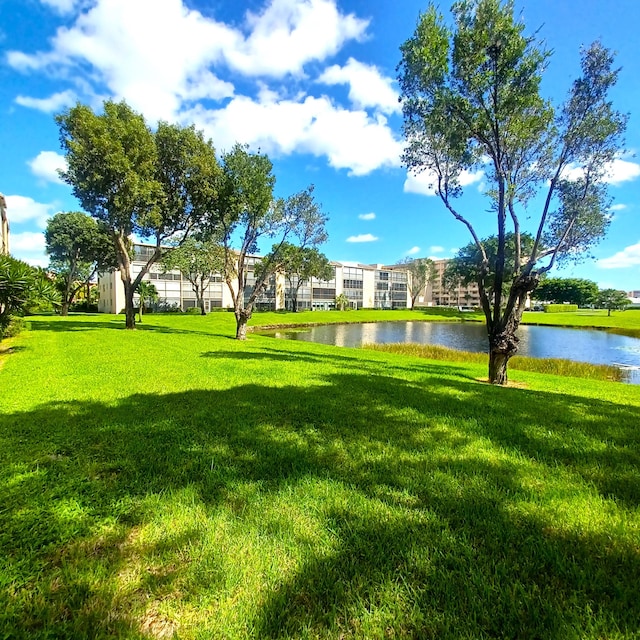 view of home's community featuring a lawn and a water view