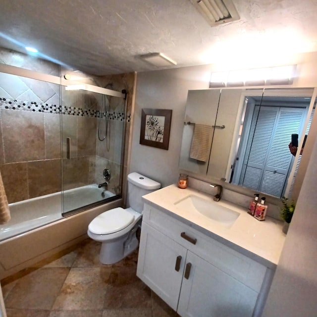 full bathroom featuring vanity, enclosed tub / shower combo, and toilet