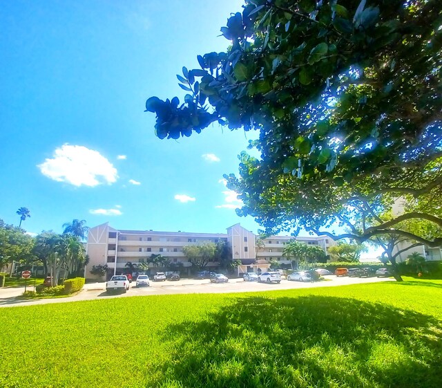 view of property's community with a water view and a lawn