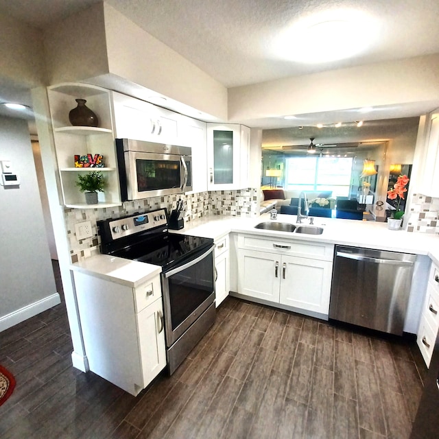 kitchen with stainless steel appliances, light countertops, wood finish floors, white cabinetry, and a sink