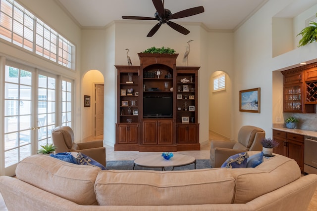 living room with ornamental molding, a high ceiling, and a wealth of natural light