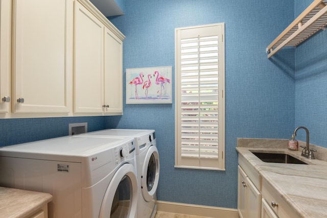 clothes washing area featuring sink, independent washer and dryer, and cabinets