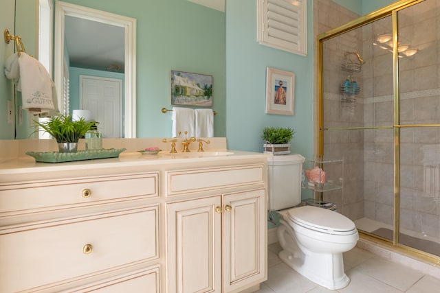 bathroom with toilet, vanity, tile patterned floors, and a shower with door