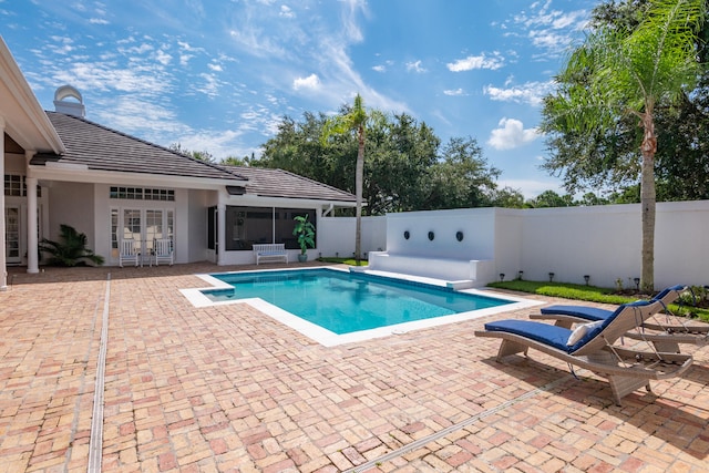 view of swimming pool featuring french doors and a patio