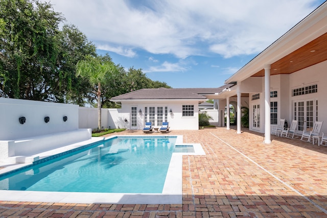 view of swimming pool featuring french doors and a patio area