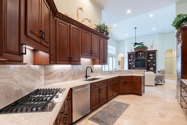 kitchen featuring kitchen peninsula, tasteful backsplash, appliances with stainless steel finishes, crown molding, and sink