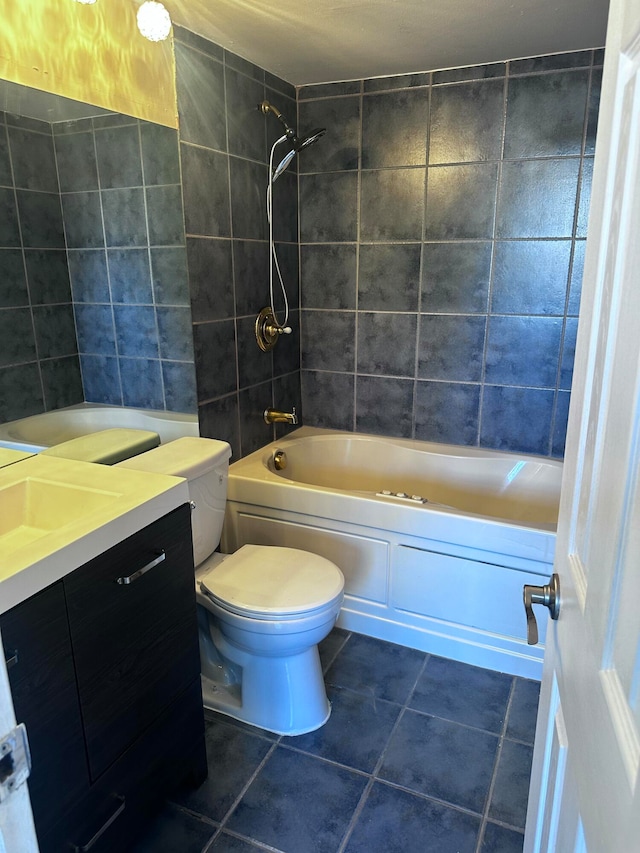 full bathroom featuring tiled shower / bath, vanity, toilet, and tile patterned flooring