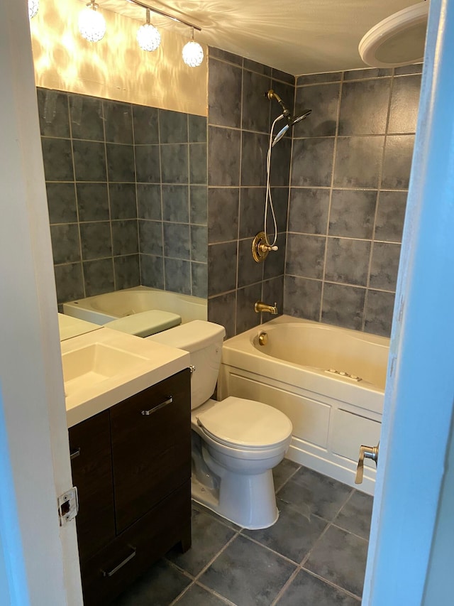 full bathroom featuring toilet, tiled shower / bath, vanity, and tile patterned floors