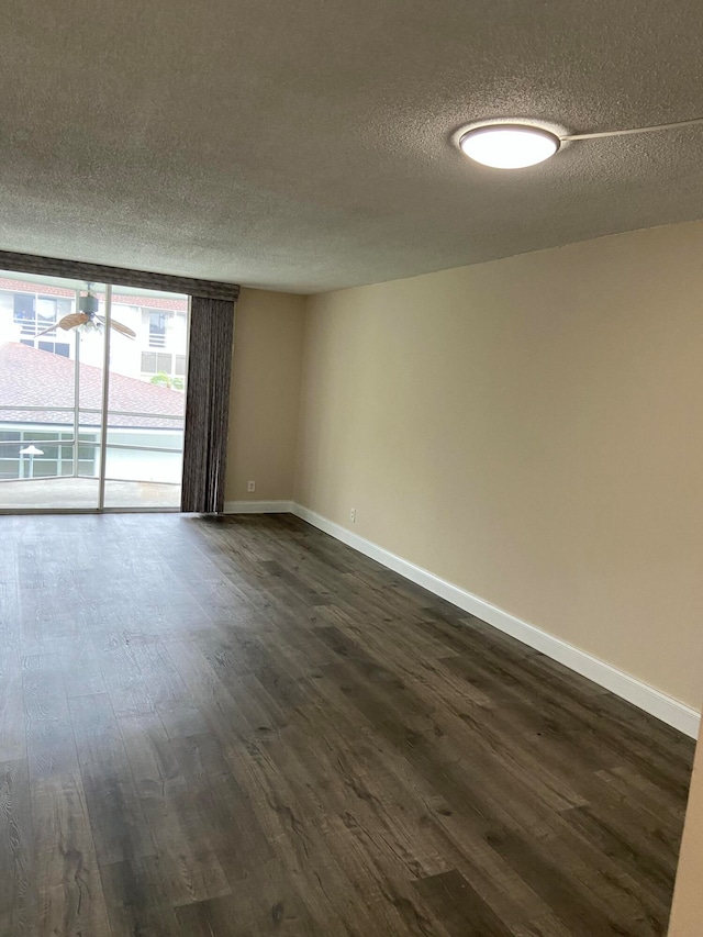 spare room featuring a textured ceiling and dark wood-type flooring