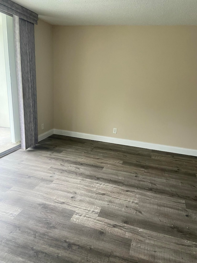 unfurnished room with hardwood / wood-style floors and a textured ceiling