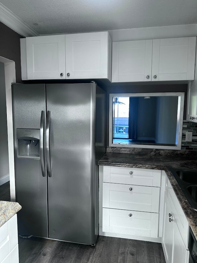 kitchen with stainless steel fridge, white cabinets, dark stone countertops, and dark hardwood / wood-style flooring