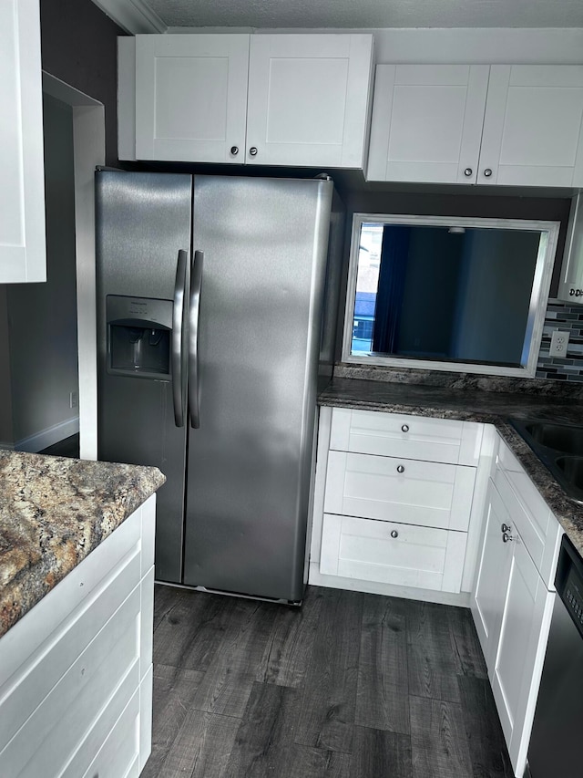 kitchen featuring decorative backsplash, white cabinets, dark hardwood / wood-style flooring, dark stone countertops, and stainless steel appliances