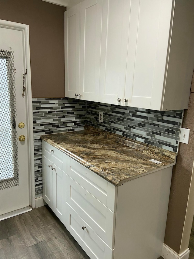 kitchen featuring white cabinetry and dark stone countertops