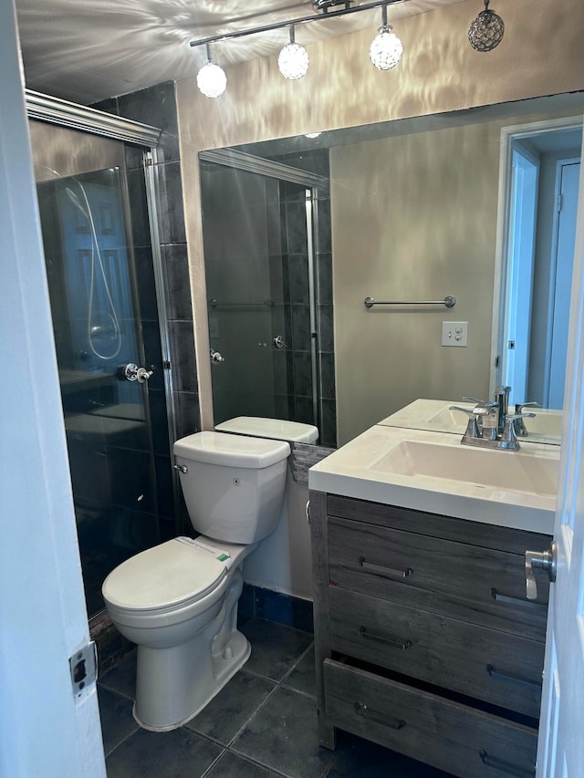 bathroom featuring vanity, toilet, tile patterned floors, and a shower with shower door