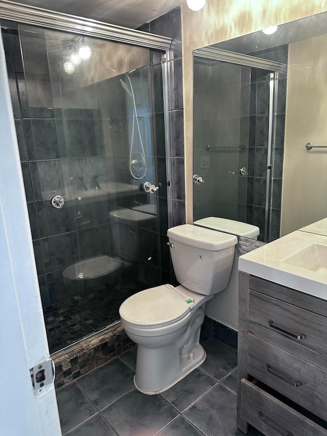 bathroom with toilet, tile patterned flooring, vanity, and a shower with door