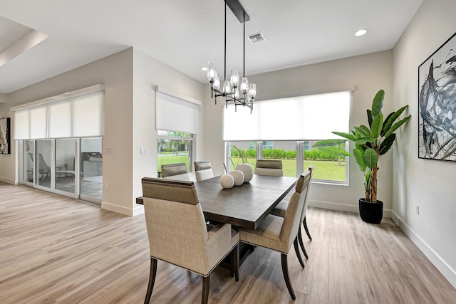 dining room featuring a wealth of natural light, light hardwood / wood-style flooring, and an inviting chandelier