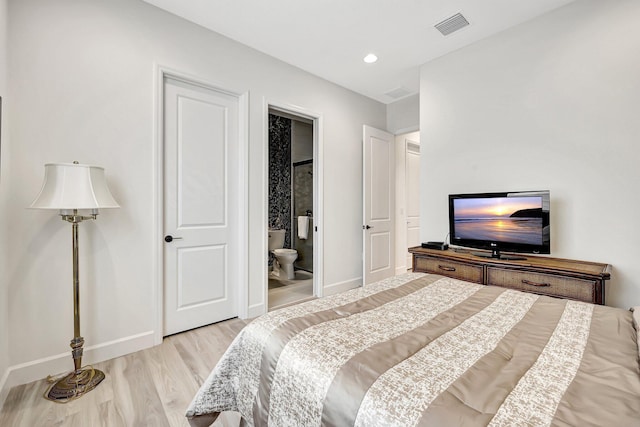 bedroom featuring connected bathroom and light wood-type flooring