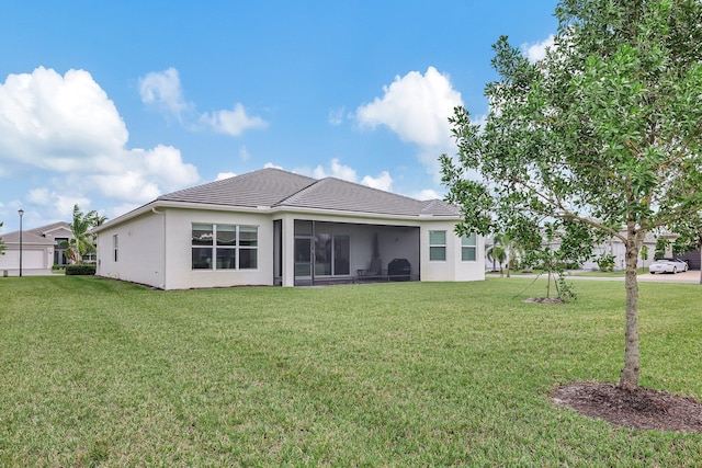 back of property featuring a lawn and a sunroom