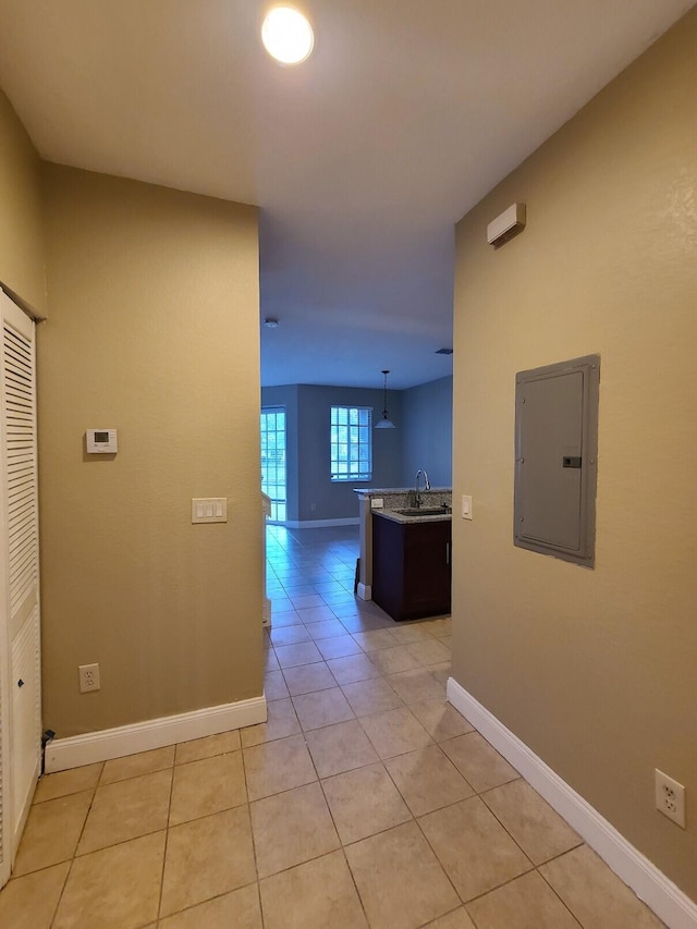 hallway featuring electric panel and light tile patterned floors