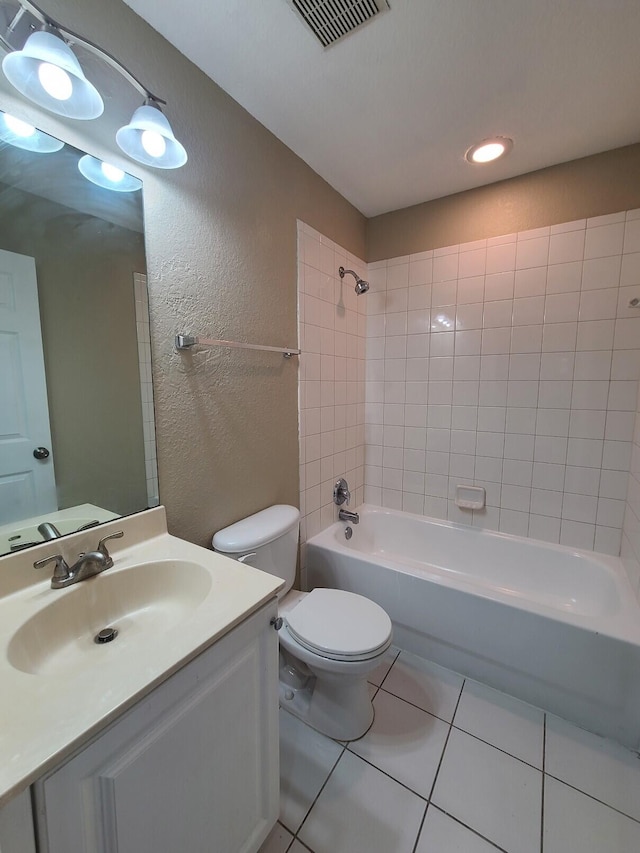 full bathroom featuring tiled shower / bath, vanity, toilet, and tile patterned flooring