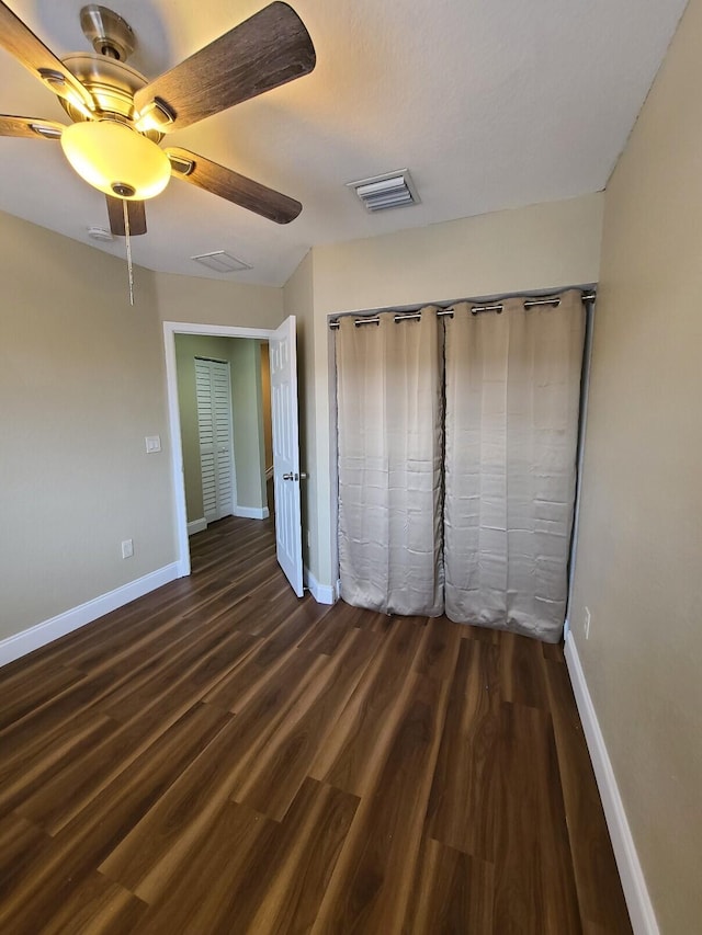 unfurnished bedroom with dark hardwood / wood-style flooring and ceiling fan