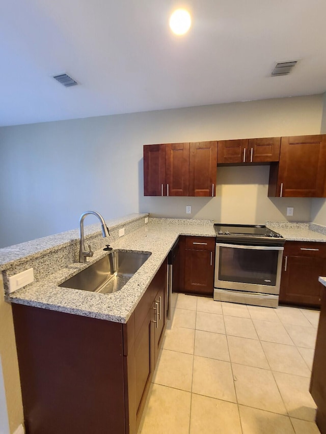 kitchen with kitchen peninsula, light tile patterned floors, light stone countertops, electric stove, and sink