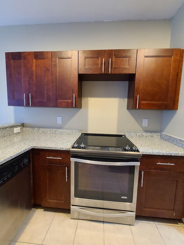 kitchen with light stone countertops, stainless steel appliances, and light tile patterned floors