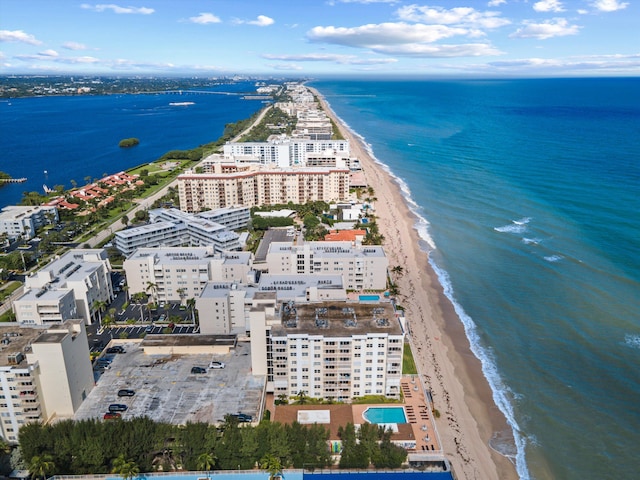 birds eye view of property with a water view and a beach view