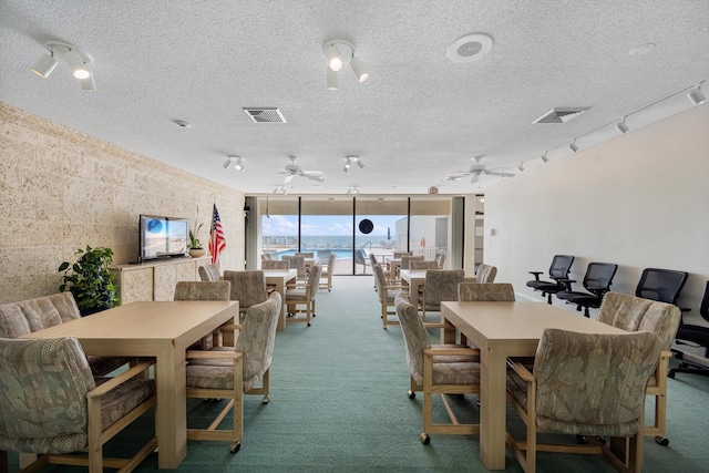 dining area with a textured ceiling, carpet flooring, and ceiling fan