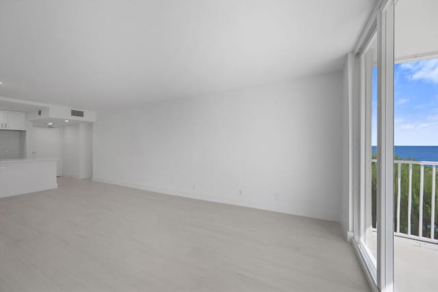 unfurnished living room with a healthy amount of sunlight and a water view