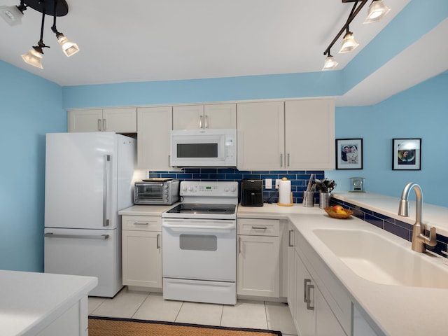 kitchen featuring backsplash, sink, white cabinetry, and white appliances