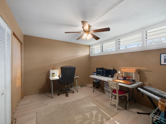 office area with light hardwood / wood-style flooring, a textured ceiling, and ceiling fan