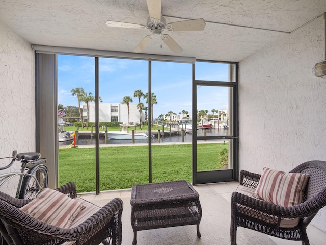 sunroom / solarium featuring a water view and ceiling fan