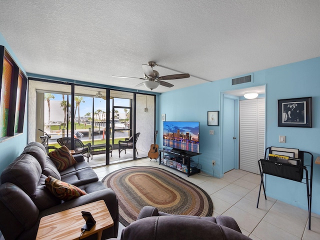 tiled living room with a textured ceiling and ceiling fan