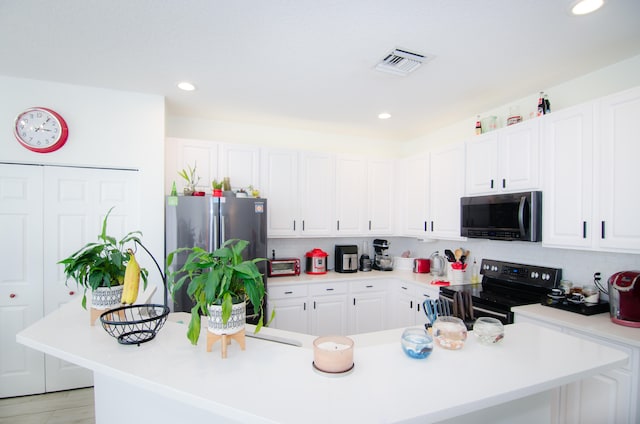 kitchen with stainless steel appliances, light hardwood / wood-style floors, white cabinetry, and decorative backsplash