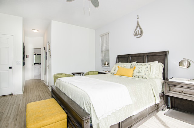 bedroom featuring light wood-type flooring, ceiling fan, and ensuite bathroom