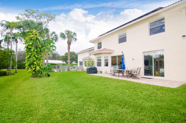 rear view of house featuring a patio area and a yard