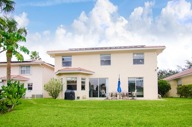 rear view of property with a lawn and a patio