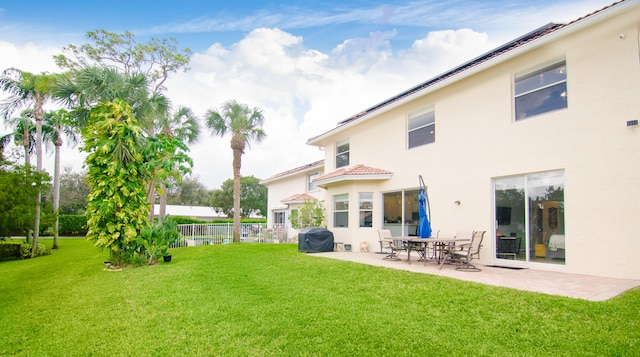 back of property with a lawn and a patio area