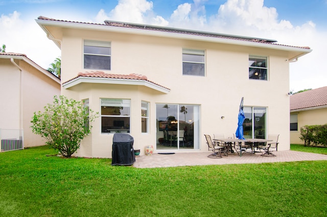 rear view of house with a patio and a yard