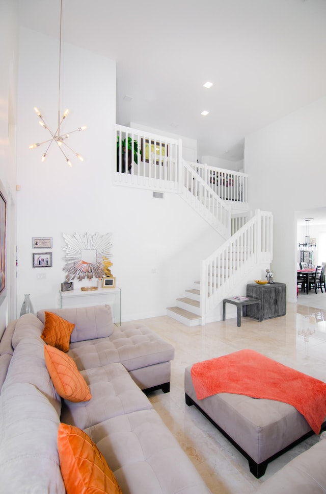 living room featuring a towering ceiling and a chandelier