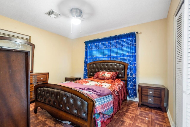 bedroom featuring a closet, dark parquet floors, a textured ceiling, and ceiling fan