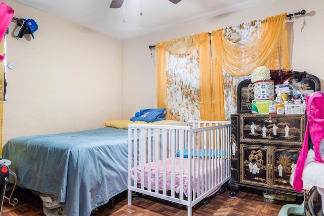 bedroom with ceiling fan and dark parquet flooring