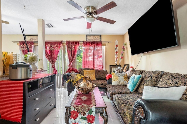 living room featuring ceiling fan, a textured ceiling, and light tile patterned floors