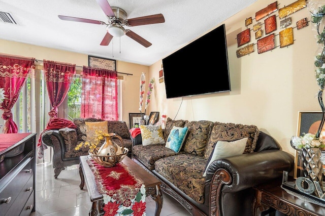 living room featuring ceiling fan, a textured ceiling, and light tile patterned flooring