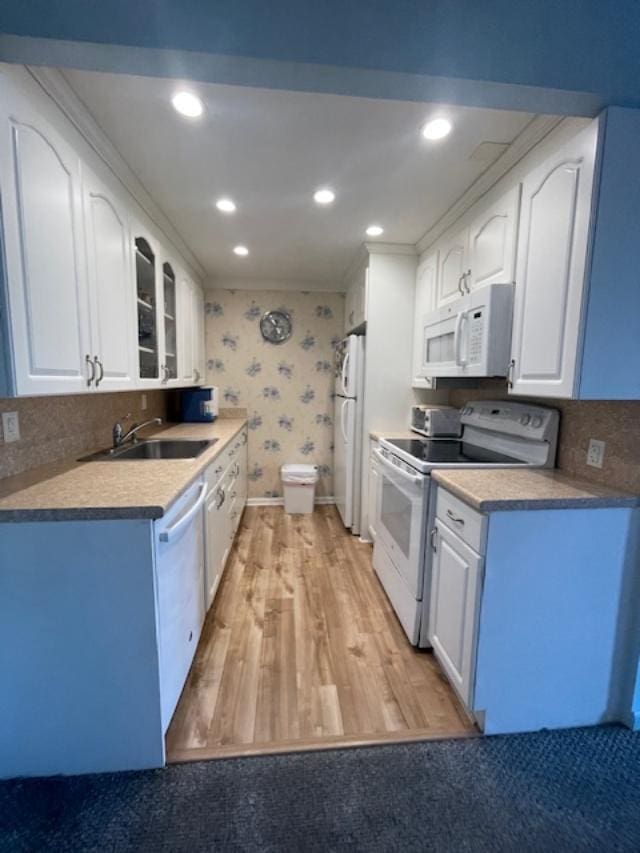 kitchen with white appliances, sink, and white cabinets