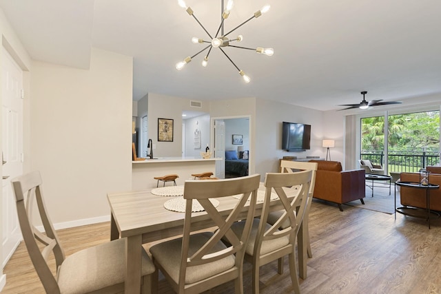 dining area featuring ceiling fan with notable chandelier and light wood-type flooring